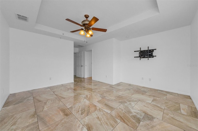 5030 Herring Ct, New Port Richey, FL 34652 - unfurnished room with a tray ceiling and a ceiling fan