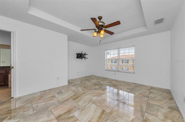 5030 Herring Ct, New Port Richey, FL 34652 - empty room with a tray ceiling, ceiling fan, and marble finish floors