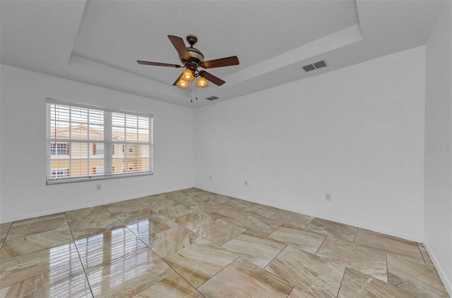 5030 Herring Ct, New Port Richey, FL 34652 - unfurnished room with a tray ceiling and a ceiling fan