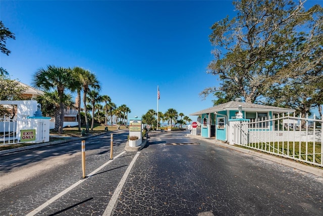 5030 Herring Ct, New Port Richey, FL 34652 - view of asphalt road featuring traffic signs, curbs, a gated entry, and a gate
