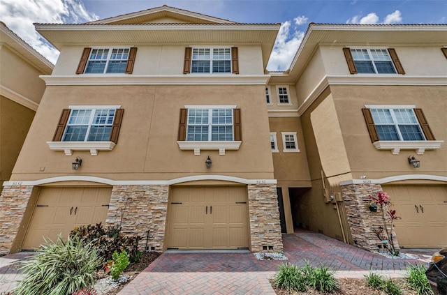 5030 Herring Ct, New Port Richey, FL 34652 - view of property featuring stucco siding, stone siding, and a garage