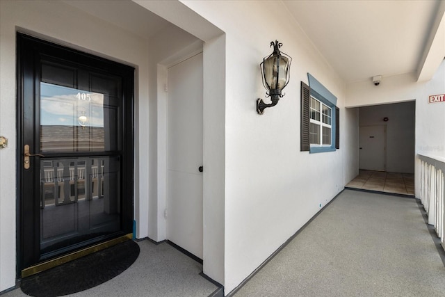 139 Bluff View Dr Unit 405, Belleair Bluffs, FL 33770 - view of exterior entry with stucco siding, a security system, and a porch