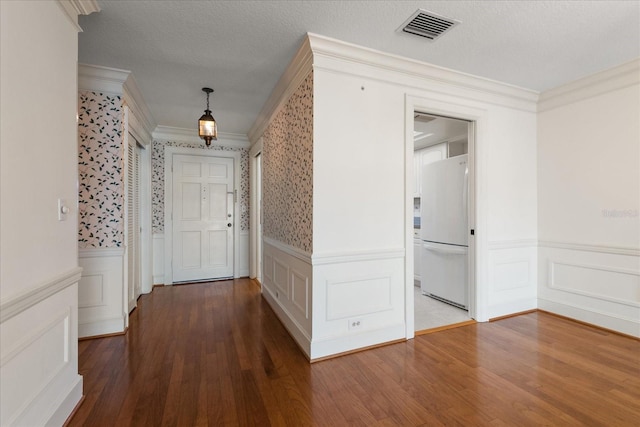 139 Bluff View Dr Unit 405, Belleair Bluffs, FL 33770 - hallway featuring a wainscoted wall, ornamental molding, wood finished floors, and a decorative wall
