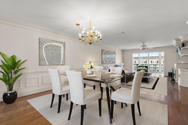 139 Bluff View Dr Unit 405, Belleair Bluffs, FL 33770 - dining room featuring ornamental molding, wood finished floors, a chandelier, ceiling fan, and a textured ceiling