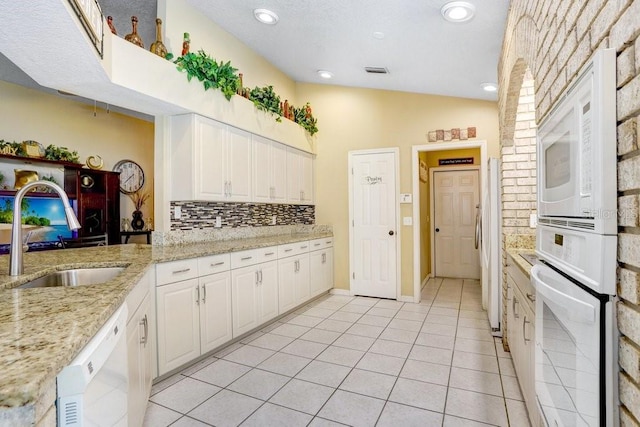 7101 Bucks Ford Dr, Riverview, FL 33578 - kitchen featuring white appliances, backsplash, white cabinets, light tile patterned floors, and light stone counters