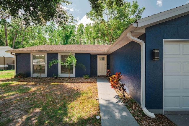 5346 Black Pine Dr, Tampa, FL 33624 - doorway to property with an attached garage and stucco siding