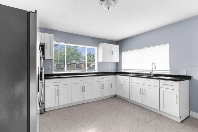 9310 N 12th St, Tampa, FL 33612 - kitchen with stainless steel appliances, white cabinetry, and dark countertops