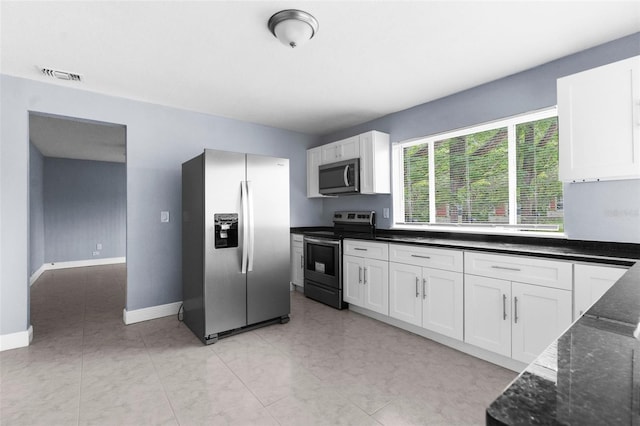 9310 N 12th St, Tampa, FL 33612 - kitchen featuring stainless steel appliances, white cabinetry, and dark stone counters