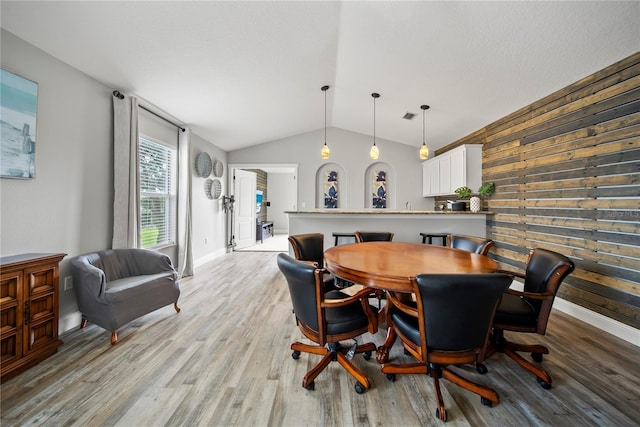 4512 Pointe O Woods Dr, Wesley Chapel, FL 33543 - dining room with vaulted ceiling, light wood-type flooring, and wooden walls