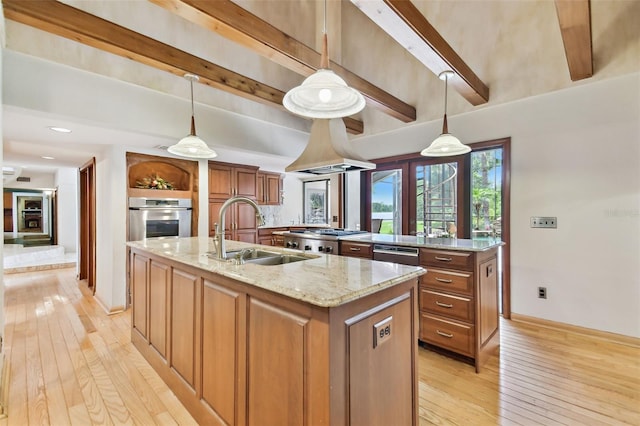 2103 N Golfview Dr, Plant City, FL 33566 - kitchen featuring appliances with stainless steel finishes, a kitchen island with sink, light wood-style flooring, beamed ceiling, and brown cabinetry