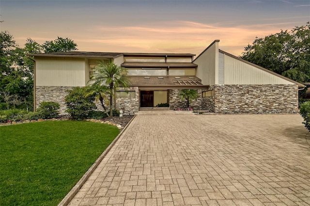 2103 N Golfview Dr, Plant City, FL 33566 - mid-century home featuring stone siding, a front yard, and decorative driveway