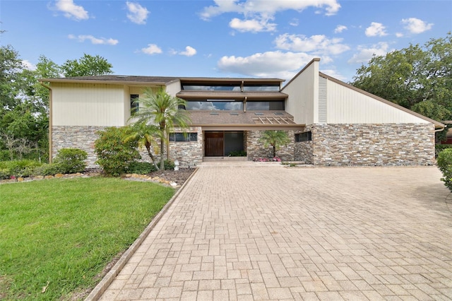 2103 N Golfview Dr, Plant City, FL 33566 - mid-century home featuring stone siding, a front yard, and decorative driveway