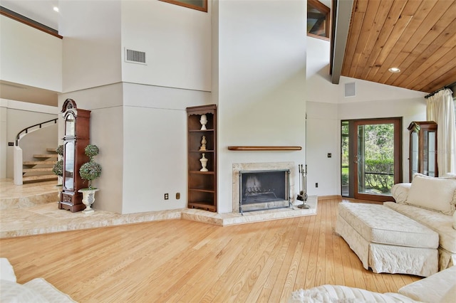 2103 N Golfview Dr, Plant City, FL 33566 - living area featuring hardwood / wood-style flooring, a fireplace with raised hearth, high vaulted ceiling, stairway, and beamed ceiling