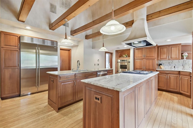 2103 N Golfview Dr, Plant City, FL 33566 - kitchen with appliances with stainless steel finishes, a kitchen island with sink, light wood-type flooring, beamed ceiling, and brown cabinets