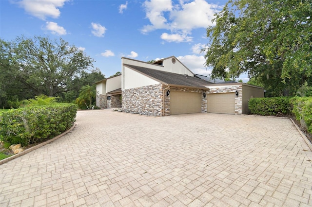 2103 N Golfview Dr, Plant City, FL 33566 - view of side of home with stone siding, a garage, and decorative driveway