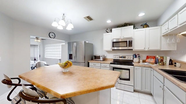 7010 Kendall Heath Way, Land O Lakes, FL 34637 - kitchen with appliances with stainless steel finishes, a center island, light countertops, a breakfast bar, and recessed lighting