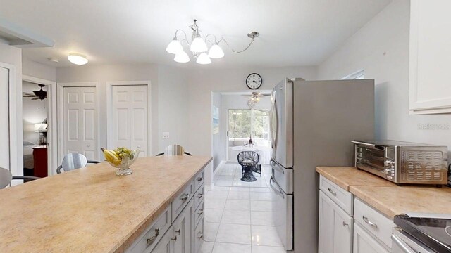 7010 Kendall Heath Way, Land O Lakes, FL 34637 - kitchen with a chandelier, light tile patterned flooring, light countertops, stainless steel range oven, and ceiling fan