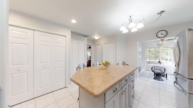 7010 Kendall Heath Way, Land O Lakes, FL 34637 - kitchen with freestanding refrigerator, light tile patterned floors, a chandelier, light countertops, and a kitchen island