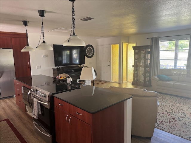 10185 Santiago Ct, Seminole, FL 33776 - kitchen with stainless steel appliances, open floor plan, dark countertops, wood finished floors, and a textured ceiling