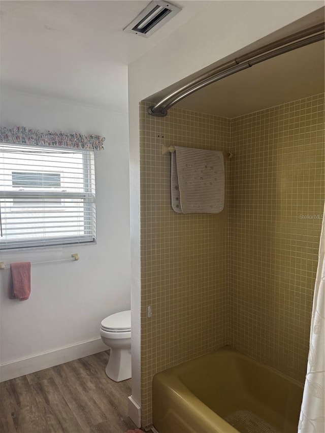 10185 Santiago Ct, Seminole, FL 33776 - bathroom featuring shower / bath combo with shower curtain and wood finished floors