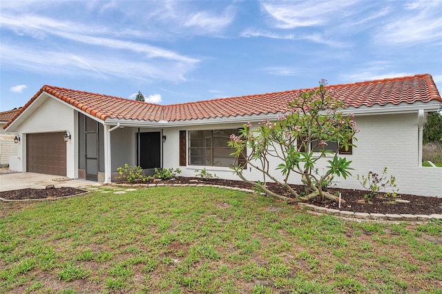 734 Flamingo Dr, Apollo Beach, FL 33572 - view of front of property featuring a garage, a tile roof, brick siding, a front yard, and concrete driveway