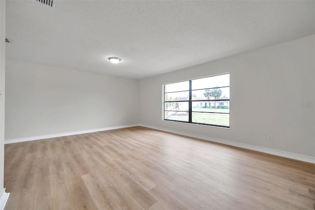 734 Flamingo Dr, Apollo Beach, FL 33572 - empty room featuring light wood-style floors and a textured ceiling