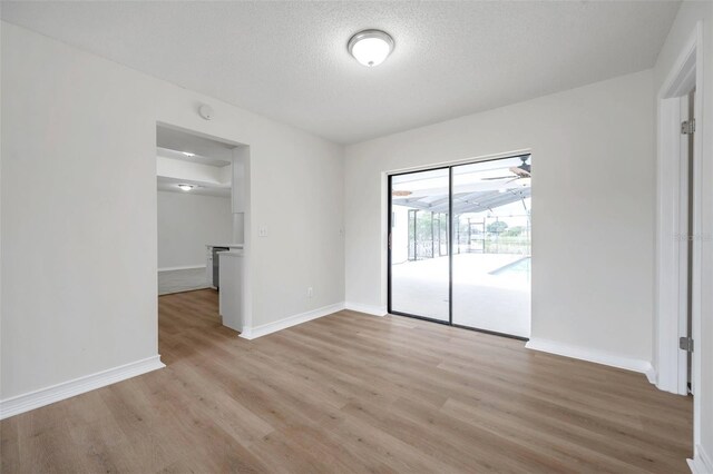 734 Flamingo Dr, Apollo Beach, FL 33572 - spare room with light wood finished floors and a textured ceiling