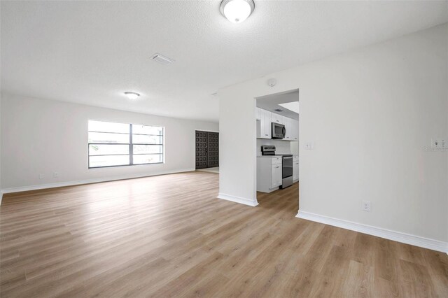 734 Flamingo Dr, Apollo Beach, FL 33572 - unfurnished living room with light wood-type flooring and baseboards