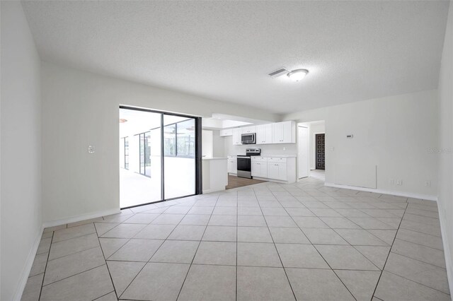 734 Flamingo Dr, Apollo Beach, FL 33572 - unfurnished living room featuring a textured ceiling and light tile patterned floors
