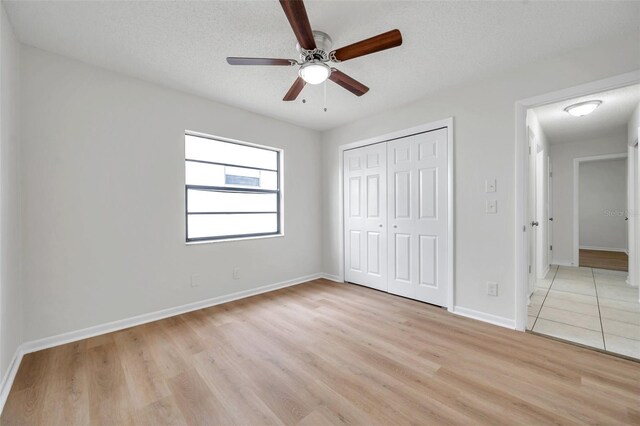 734 Flamingo Dr, Apollo Beach, FL 33572 - unfurnished bedroom with light wood-type flooring, a closet, and a ceiling fan