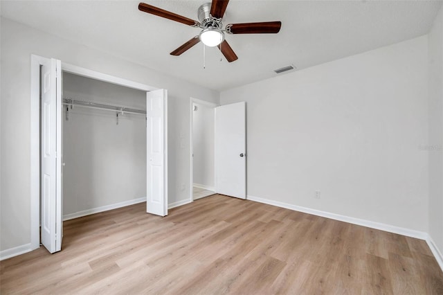 734 Flamingo Dr, Apollo Beach, FL 33572 - unfurnished bedroom with light wood-style flooring, a closet, and a ceiling fan