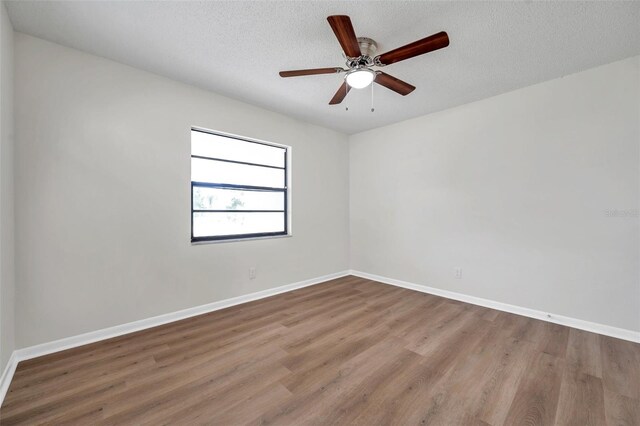 734 Flamingo Dr, Apollo Beach, FL 33572 - spare room featuring wood finished floors, a textured ceiling, and a ceiling fan