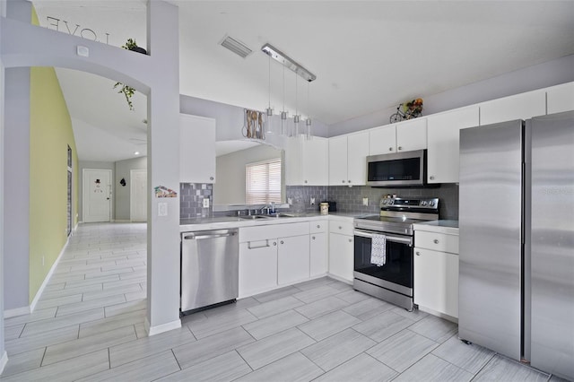 8526 Quarter Horse Dr, Riverview, FL 33578 - kitchen featuring appliances with stainless steel finishes, light countertops, decorative backsplash, white cabinetry, and decorative light fixtures