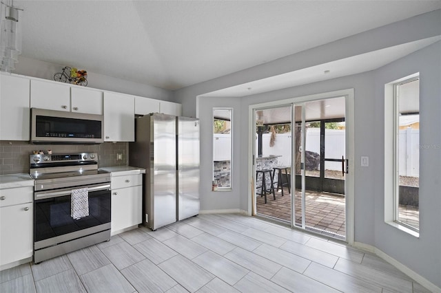 8526 Quarter Horse Dr, Riverview, FL 33578 - kitchen featuring appliances with stainless steel finishes, healthy amount of natural light, light countertops, and backsplash