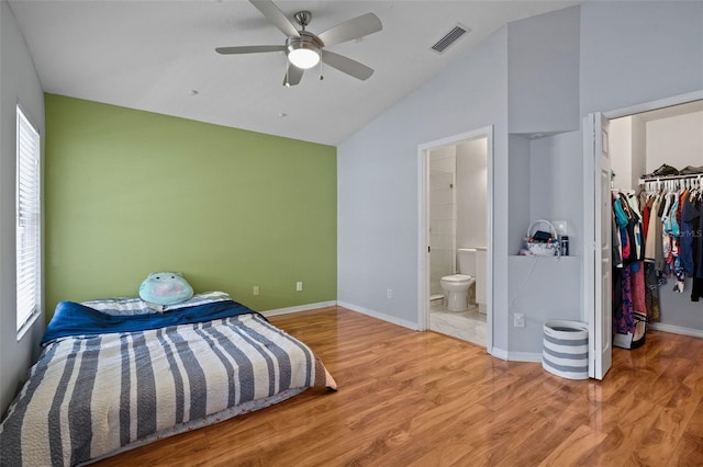 8526 Quarter Horse Dr, Riverview, FL 33578 - unfurnished bedroom featuring vaulted ceiling, a walk in closet, wood finished floors, a closet, and connected bathroom