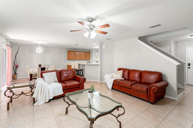 17509 Queensland St, Land O Lakes, FL 34638 - living room featuring stairs, light tile patterned floors, ceiling fan, and a textured ceiling