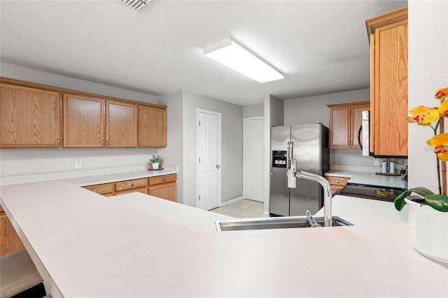 17509 Queensland St, Land O Lakes, FL 34638 - kitchen featuring stainless steel appliances, light countertops, a peninsula, and a textured ceiling