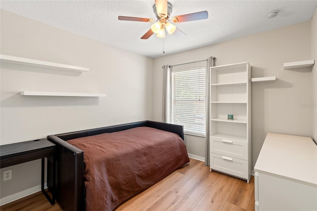 17509 Queensland St, Land O Lakes, FL 34638 - bedroom with light wood-style flooring, a textured ceiling, and a ceiling fan