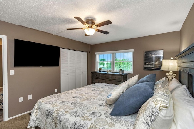 940 Virginia St Unit 303, Dunedin, FL 34698 - carpeted bedroom with a closet, a fireplace, a ceiling fan, and a textured ceiling