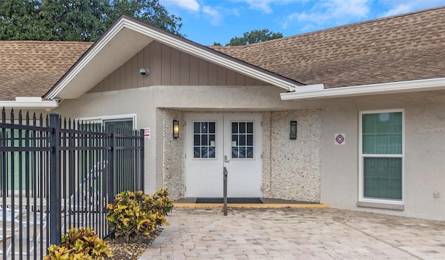 940 Virginia St Unit 303, Dunedin, FL 34698 - view of exterior entry featuring a shingled roof, stucco siding, french doors, and a patio