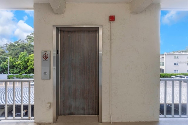 940 Virginia St Unit 303, Dunedin, FL 34698 - doorway to property with elevator, stucco siding, and a balcony