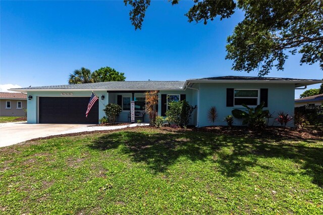 3312 Kenmore Dr, Sarasota, FL 34231 - single story home featuring stucco siding, an attached garage, driveway, and a front lawn