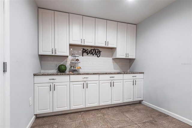 3312 Kenmore Dr, Sarasota, FL 34231 - kitchen featuring backsplash, white cabinetry, and dark stone counters