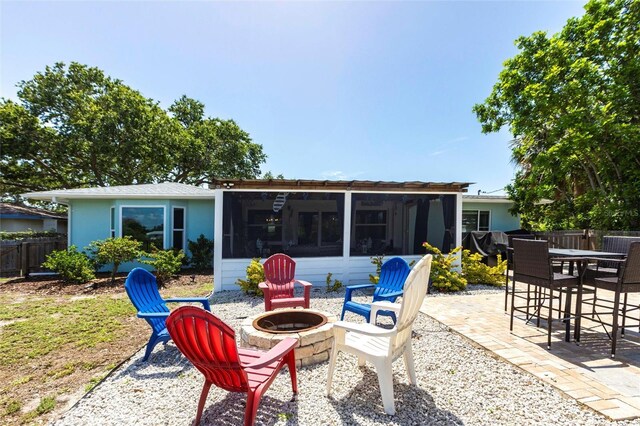 3312 Kenmore Dr, Sarasota, FL 34231 - back of property with a sunroom, a fire pit, and a patio