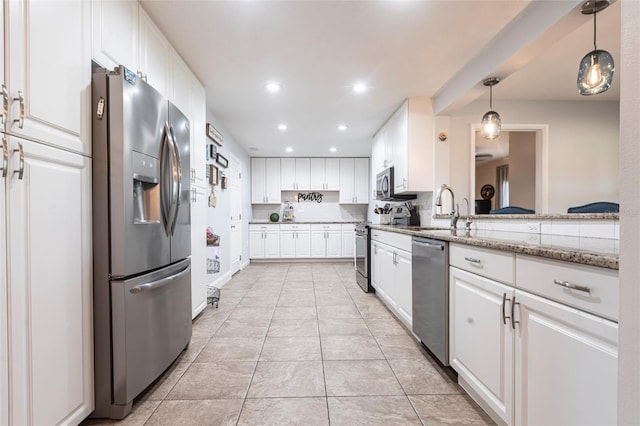 3312 Kenmore Dr, Sarasota, FL 34231 - kitchen featuring appliances with stainless steel finishes, recessed lighting, white cabinets, pendant lighting, and light tile patterned flooring