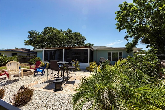 3312 Kenmore Dr, Sarasota, FL 34231 - rear view of house featuring a fire pit, a sunroom, and a patio area
