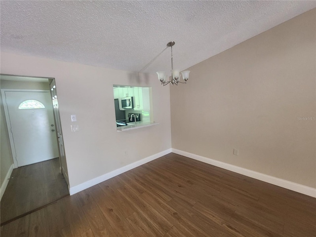 209 Corkwood Ln, Oldsmar, FL 34677 - unfurnished room featuring a chandelier, dark wood-type flooring, and a textured ceiling