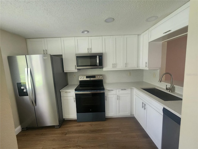 209 Corkwood Ln, Oldsmar, FL 34677 - kitchen with appliances with stainless steel finishes, dark wood-type flooring, white cabinetry, light countertops, and a textured ceiling