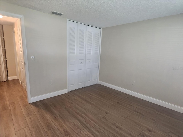 209 Corkwood Ln, Oldsmar, FL 34677 - unfurnished bedroom with wood finished floors, a closet, and a textured ceiling
