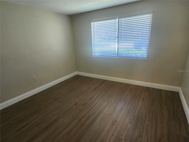 209 Corkwood Ln, Oldsmar, FL 34677 - empty room featuring dark wood-type flooring and a textured ceiling